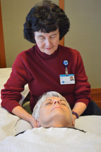 Care Dimensions volunteer Joan Charette giving Reiki to hospice patient at Kaplaln Family Hospice House
