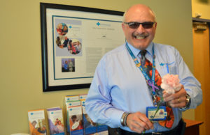 Care Dimensions chaplain Bob Hagopian holds a pink carnation like the ones he presented to hospice patients